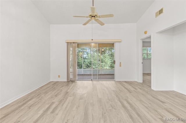 spare room featuring light hardwood / wood-style floors, vaulted ceiling, and ceiling fan