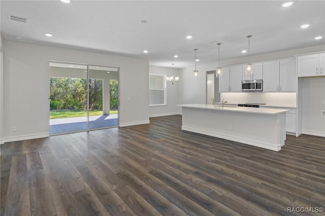 kitchen featuring stainless steel microwave, visible vents, baseboards, recessed lighting, and dark wood finished floors