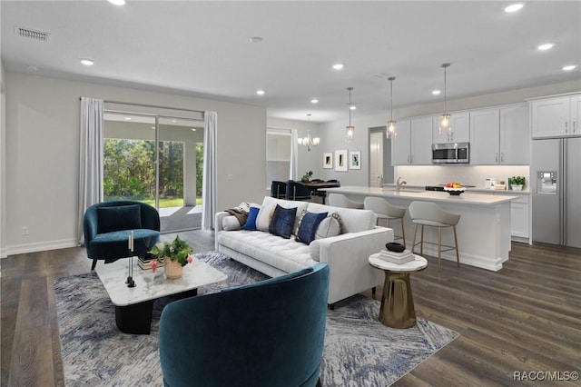 living room with dark wood finished floors, visible vents, baseboards, and recessed lighting