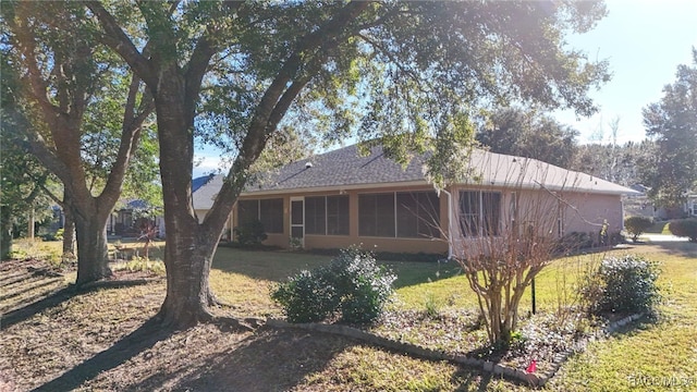 back of property with a yard and a sunroom