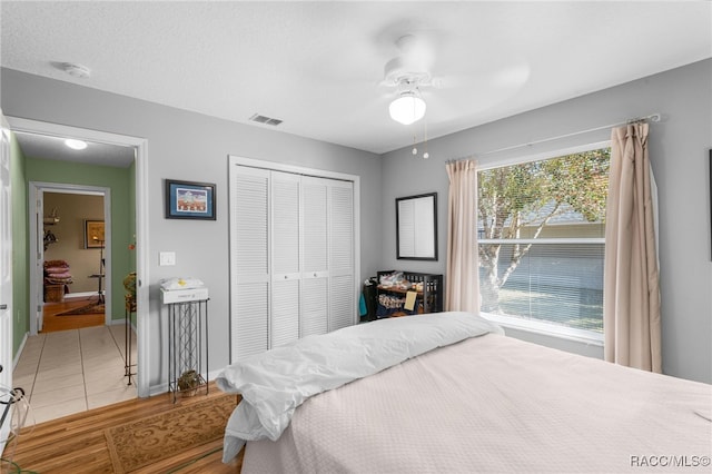 bedroom featuring ceiling fan, light hardwood / wood-style floors, and a closet