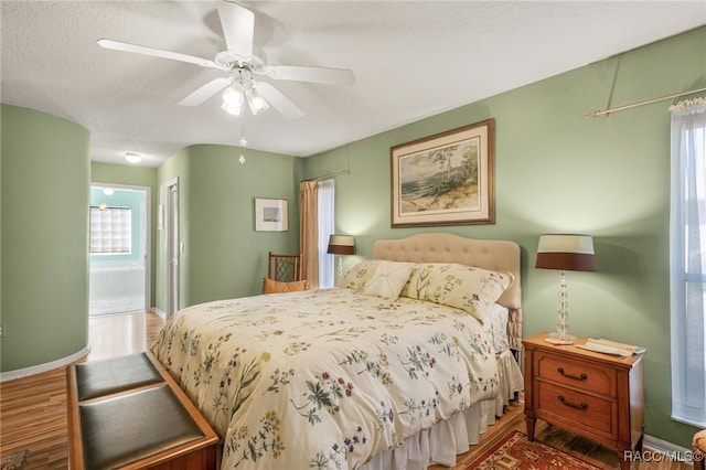 bedroom featuring hardwood / wood-style flooring, ceiling fan, ensuite bathroom, a textured ceiling, and a closet