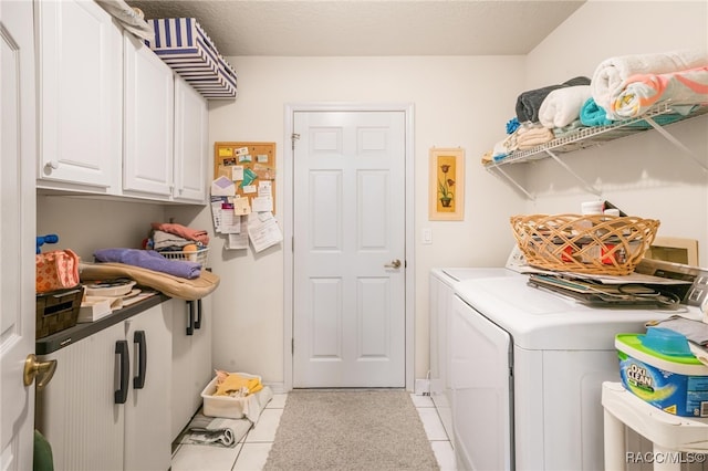 laundry area with cabinets, washing machine and dryer, and light tile patterned floors