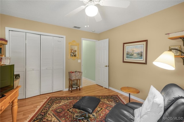 living room with ceiling fan and light hardwood / wood-style flooring