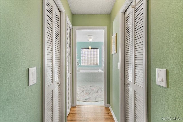 hallway with light hardwood / wood-style flooring