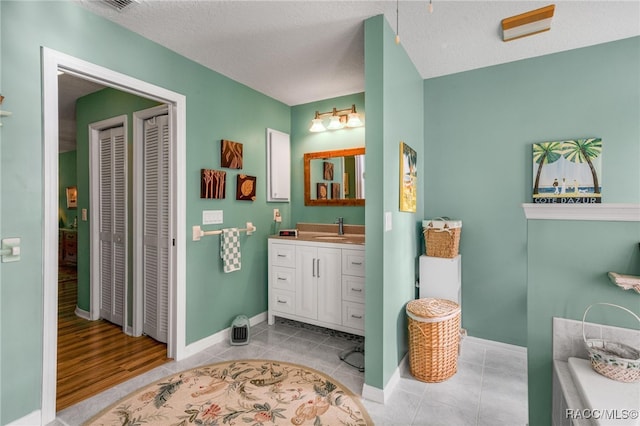 bathroom with vanity, tile patterned flooring, and a textured ceiling