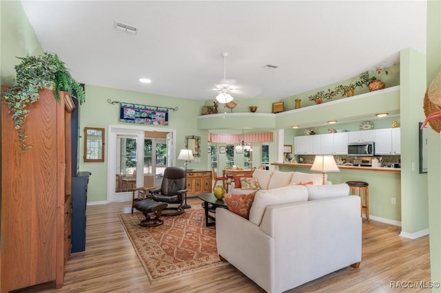 living room with ceiling fan and light hardwood / wood-style floors