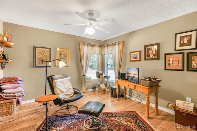 office area with ceiling fan, a textured ceiling, and light hardwood / wood-style floors