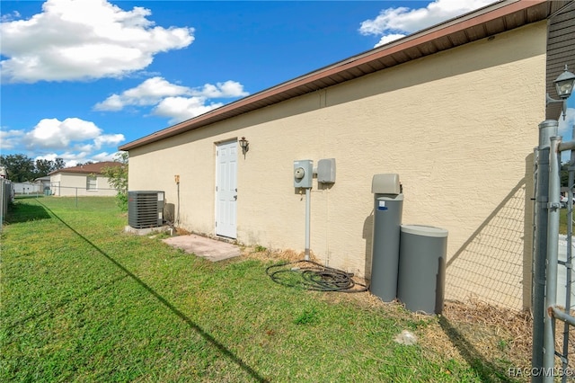 view of side of property with a lawn and central AC unit