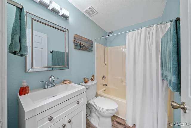 full bathroom featuring shower / bath combo, wood-type flooring, a textured ceiling, toilet, and vanity