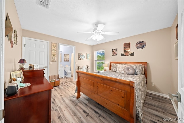 bedroom featuring hardwood / wood-style floors, a textured ceiling, ensuite bathroom, and ceiling fan