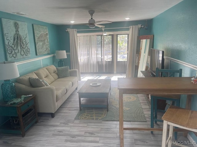 living room with visible vents, ceiling fan, and wood finished floors