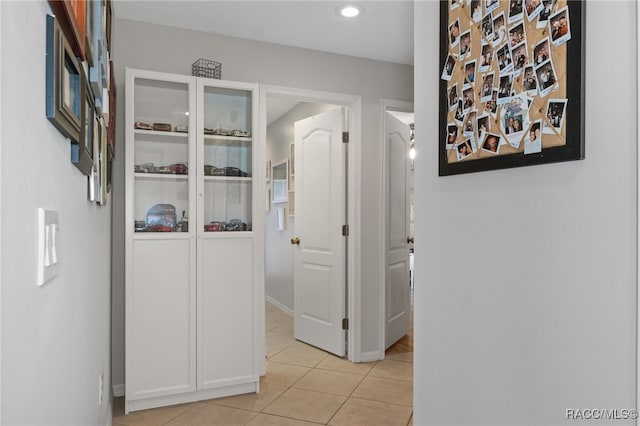 hall with light tile patterned floors