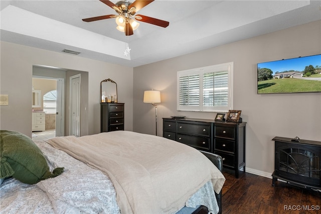 bedroom with ensuite bath, ceiling fan, dark wood-type flooring, and multiple windows