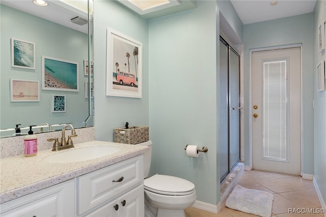 bathroom with tile patterned floors, vanity, an enclosed shower, and toilet