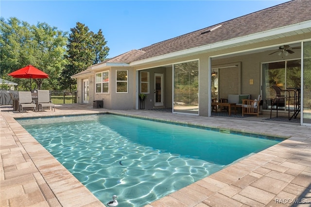 view of swimming pool with ceiling fan and a patio