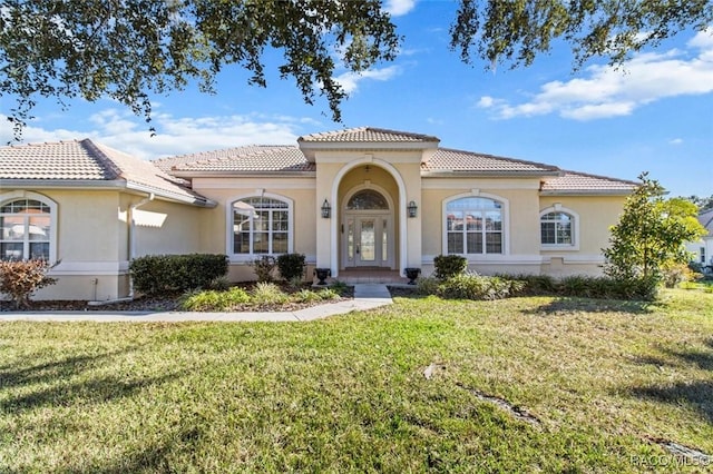 mediterranean / spanish house with a front yard