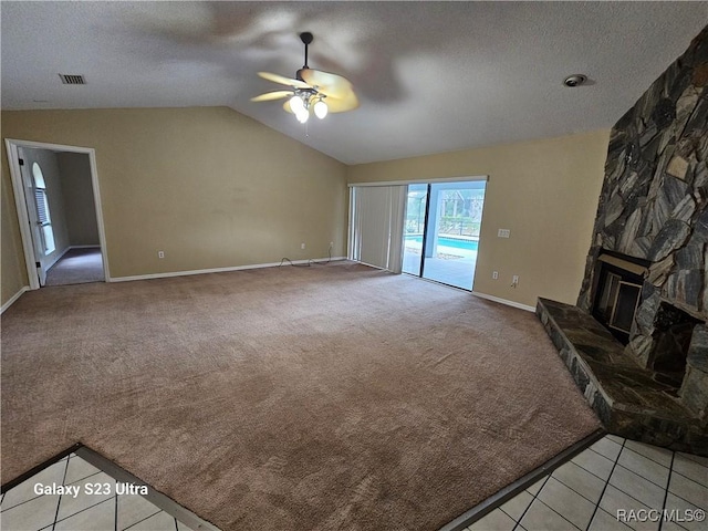 unfurnished living room featuring lofted ceiling, light carpet, ceiling fan, a textured ceiling, and a fireplace