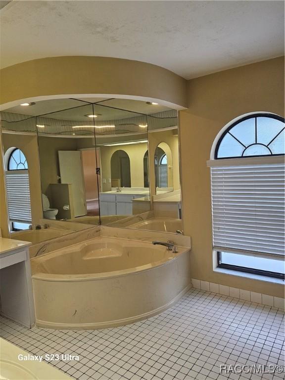 bathroom with tile patterned floors and a bathing tub