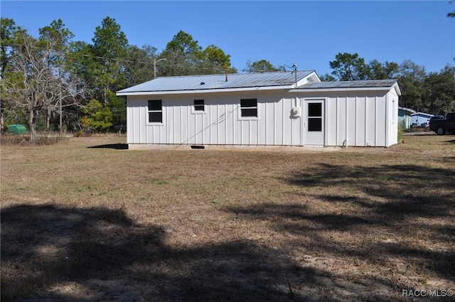 rear view of property featuring a lawn