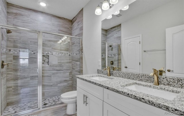 bathroom with hardwood / wood-style floors, vanity, toilet, and walk in shower