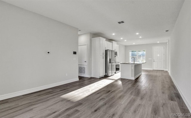 unfurnished living room with sink and dark wood-type flooring