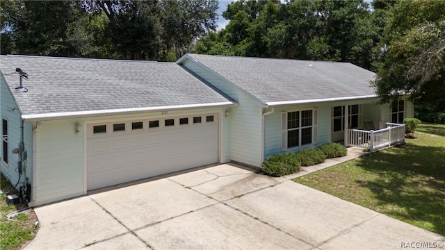 ranch-style home with a front lawn, a porch, and a garage