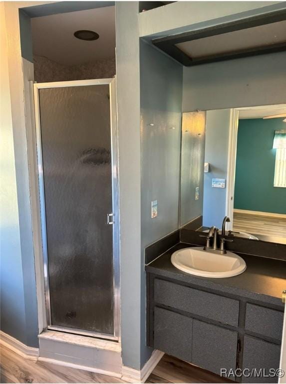 full bath featuring a shower stall, vanity, and wood finished floors