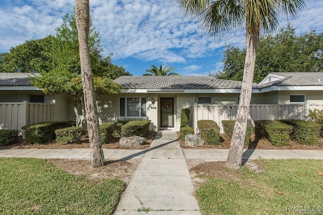 view of front of house with fence and stucco siding