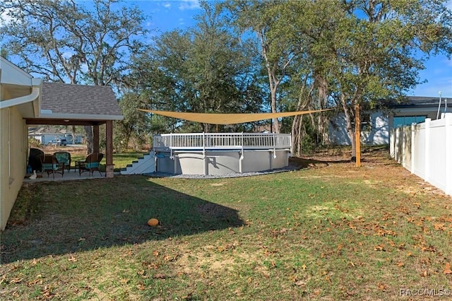 view of yard featuring a covered pool and fence