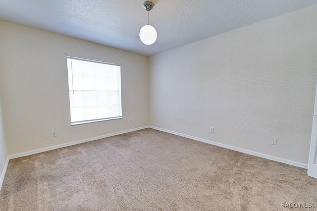 carpeted empty room featuring a textured ceiling