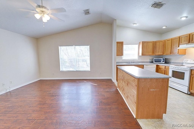 kitchen featuring lofted ceiling, white appliances, light hardwood / wood-style floors, and kitchen peninsula