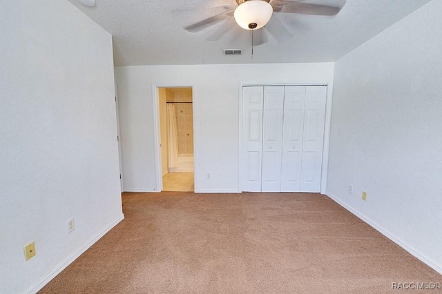 unfurnished bedroom with ceiling fan, carpet floors, ensuite bath, and a closet