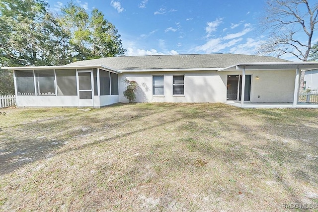 rear view of house with a yard, a patio area, and a sunroom