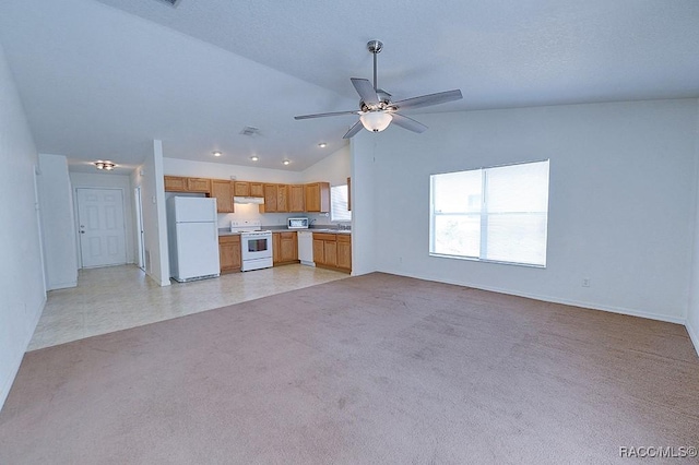 unfurnished living room featuring vaulted ceiling, sink, light colored carpet, and ceiling fan