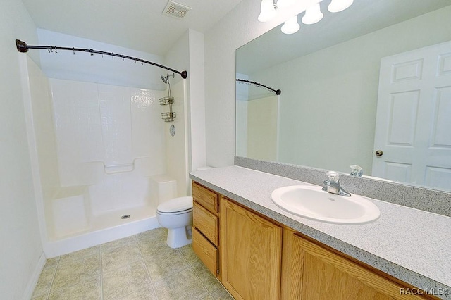 bathroom featuring vanity, tile patterned floors, toilet, and walk in shower