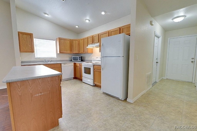 kitchen with vaulted ceiling, white appliances, and sink