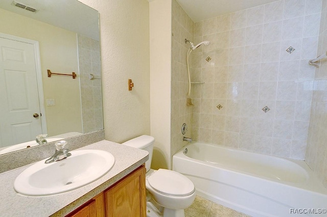 full bathroom featuring vanity, tiled shower / bath, tile patterned flooring, and toilet