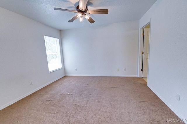 unfurnished room with ceiling fan, light colored carpet, and a textured ceiling