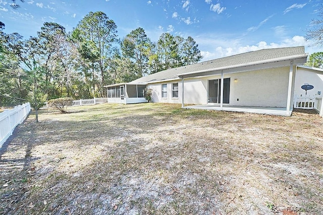 rear view of house featuring a patio area and a sunroom