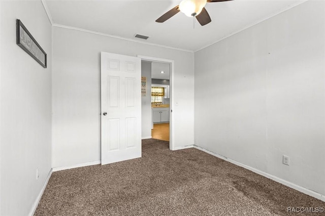 unfurnished bedroom featuring carpet floors, visible vents, crown molding, and baseboards