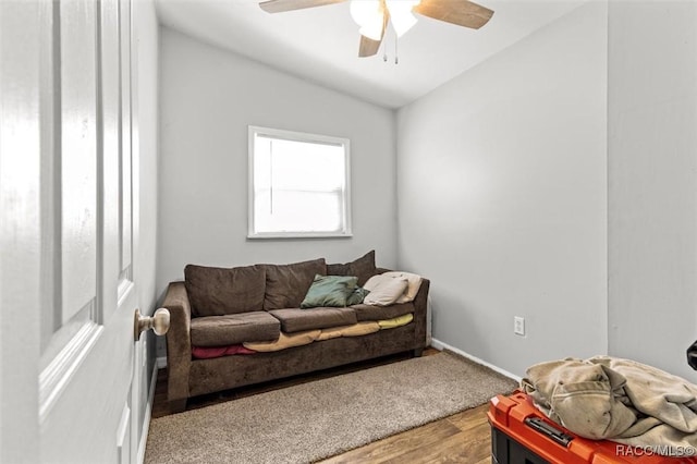 living room with ceiling fan, baseboards, and wood finished floors