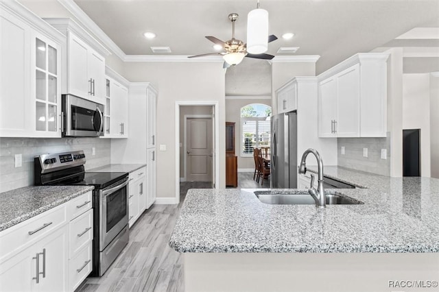 kitchen with white cabinetry, appliances with stainless steel finishes, sink, and crown molding