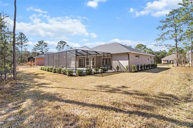 back of house featuring a yard and glass enclosure