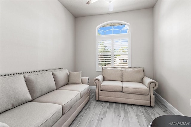 living room with ceiling fan and light wood-type flooring