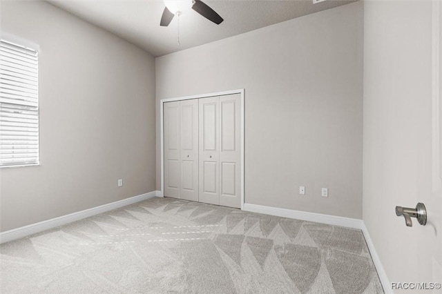 unfurnished bedroom featuring light colored carpet, ceiling fan, and a closet