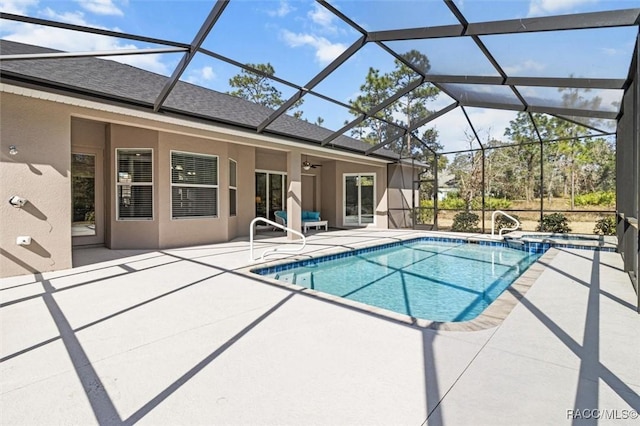 view of pool with a patio area and glass enclosure