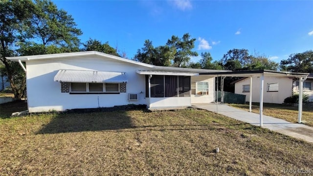 rear view of property with a lawn and a carport