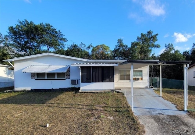 view of front facade with a front yard, a carport, and a sunroom