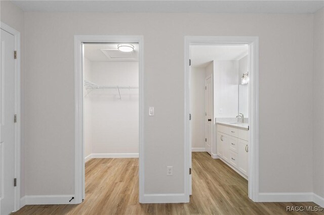 6658 N Bedstrow Blvd, Dunnellon, FL 34434 - unfurnished bedroom with light wood finished floors, a walk in closet, and attic access